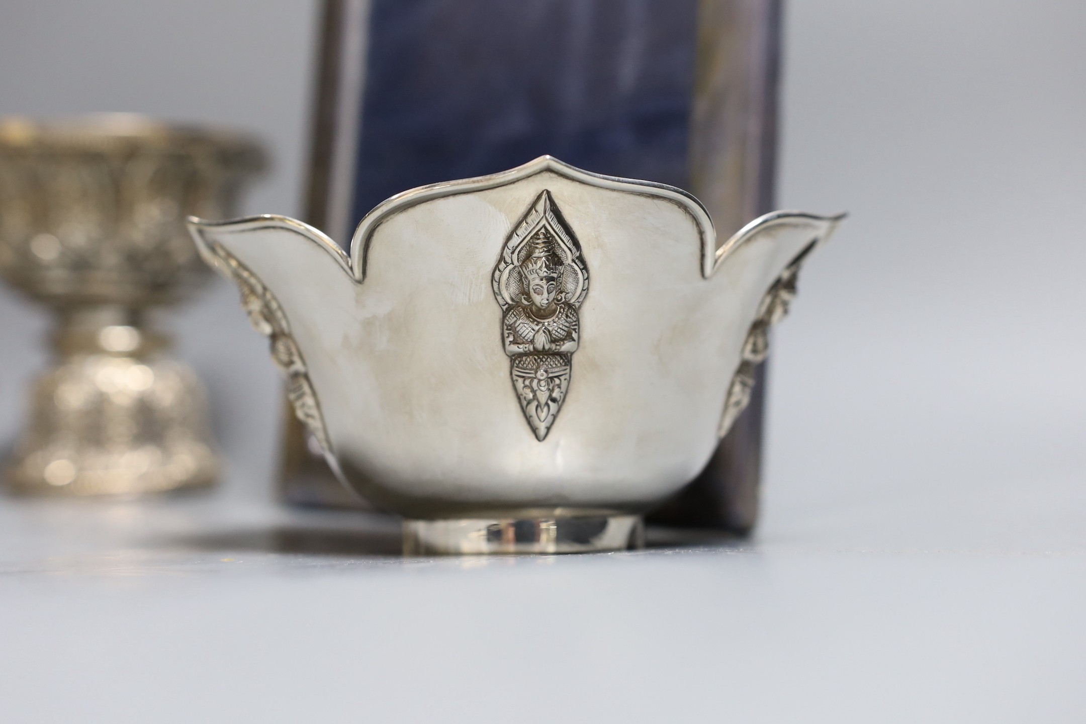 Six assorted embossed Thai white metal bowls, largest 18cm diam., and a silver photograph frame
